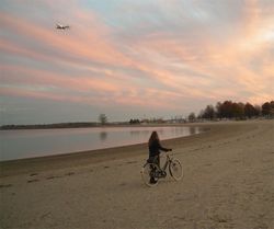Lovely bicycle woman beach sunset plane